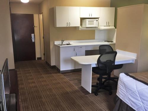 a small room with a desk and a kitchen at Extended Stay America Suites - Chicago - Itasca in Itasca