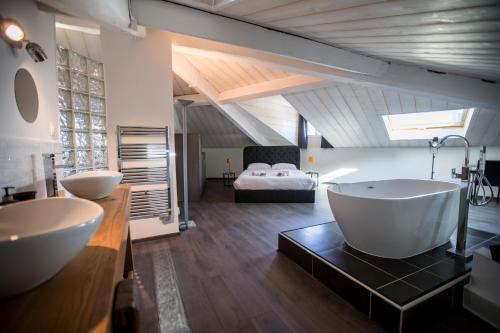 une salle de bain avec deux lavabos et un lit en arrière-plan dans l'établissement Sherlock Loft by Connexion, à Cannes