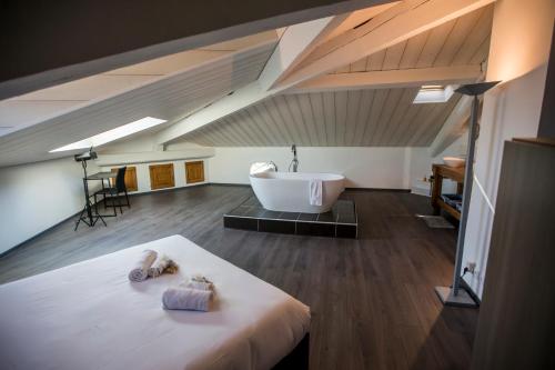 une chambre avec une baignoire et un lit avec deux serviettes dans l'établissement Sherlock Loft by Connexion, à Cannes