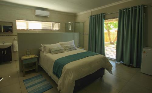 Un dormitorio con una cama grande y una ventana. en La Rose Douglas Guesthouse No loadshedding, en Douglas