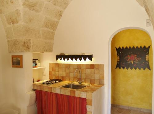 een keuken met een wastafel en een fornuis bij Case d'Artista in Savelletri di Fasano