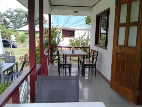 a balcony with a table and chairs and a door at Agnes Cottage - Emerald in La Digue