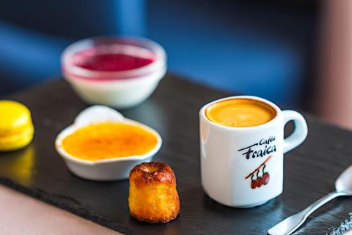 a table with a cup of coffee and a piece of food at Hotel Les Arolles in Méribel