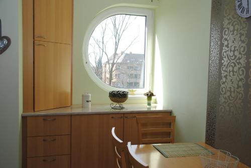 セゲドにあるSzamóca Apartmanの窓、テーブル付きのキッチンが備わります。