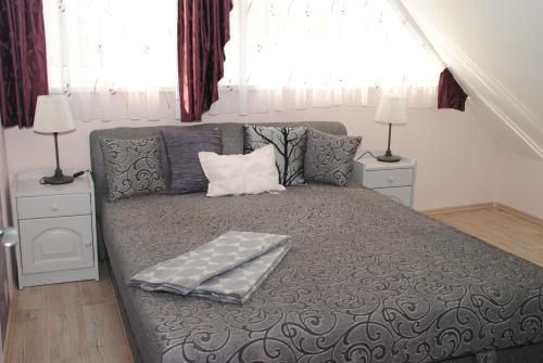 a bed in a bedroom with two night stands and two lamps at Szamóca Apartman in Szeged