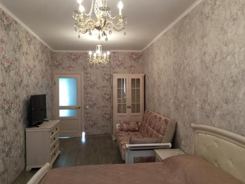 ゲレンジークにあるАпартаменты на Крымской 19 с видом на мореのベッドルーム1室(ベッド1台、シャンデリア付)