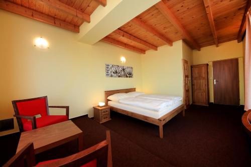 - une chambre avec un lit, une table et une chaise dans l'établissement Penzion Folbr, à Dlouhá Lhota