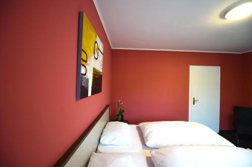 sypialnia z czerwonymi ścianami i dwoma łóżkami w obiekcie Hotel Dolce Vita w mieście Bernkastel-Kues