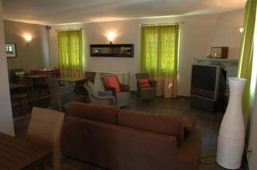 a living room with green curtains and a couch at Hôtel la Palma in Patrimonio
