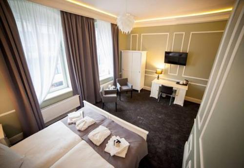 a hotel room with two beds and a television at Aparthotel Platinum Apartamenty in Inowrocław