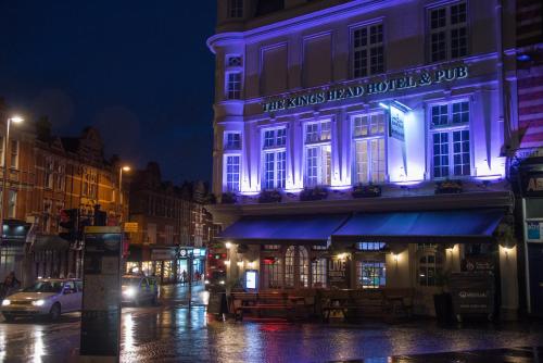 a lit up building on a city street at night at The Kings Head Hotel in London