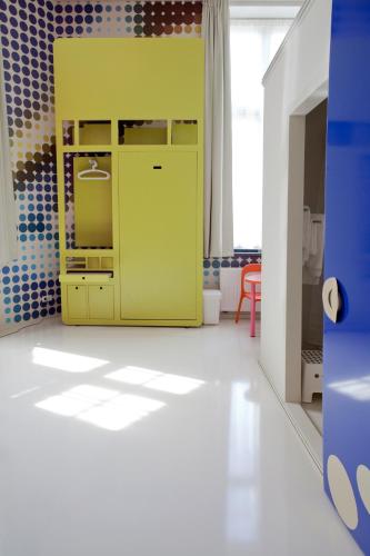 a yellow cabinet in a room with blue tiles at LABnul50 self check-in hotel Groningen in Groningen
