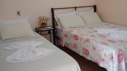 two beds sitting next to each other in a bedroom at Pousada Requinte in Vila Velha