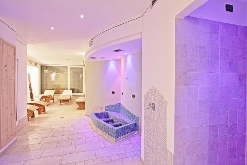 y baño con ducha y bañera azul. en Olimpionico Hotel, en Castello di Fiemme