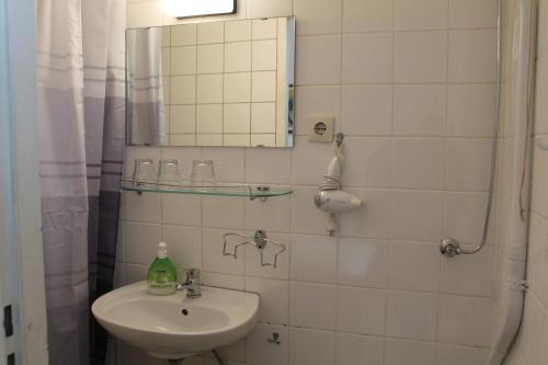 a bathroom with a sink and a mirror at Hotel Pension Waizenegger am Kurfürstendamm in Berlin