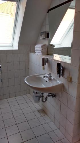 a bathroom with a sink and a mirror at City Hotel Aschersleben in Aschersleben