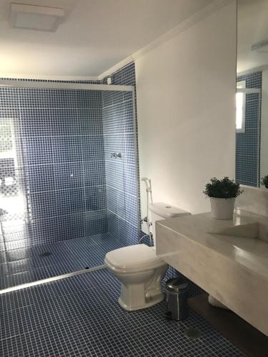 a bathroom with a toilet and a shower and a sink at Vila de Charme Suítes in Campos do Jordão