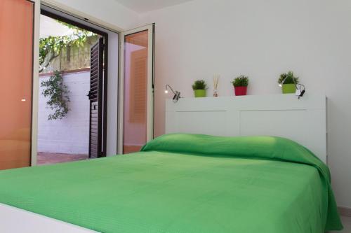 a bedroom with a green bed and a window at Piccola Oasi in Mondello