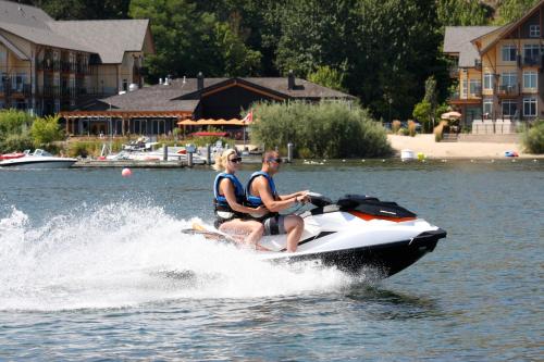 a man and woman riding on a jet ski in the water at Summerland Waterfront Resort & Spa in Summerland