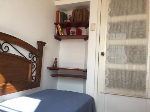 a bedroom with a bed and a window with books at Best place in Plaza Mayor Lima, Pizarro building in Lima