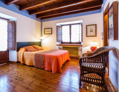 ein Schlafzimmer mit einem Bett und einem Stuhl in einem Zimmer in der Unterkunft Apartamentos La Casona De Vidiago in Vidiago