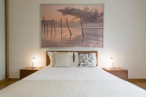 a bedroom with a large white bed with two lamps at Pena I by An Island Apart in Funchal