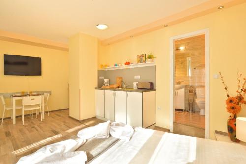 Una habitación con una cama y una cocina y una mesa. en Central studio #3, en Burgas