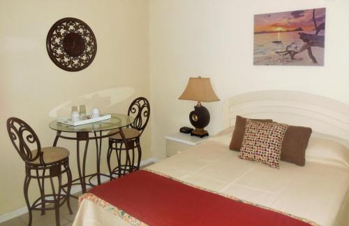 a bedroom with a bed and a table with chairs at Dundee Bay Villas in Freeport