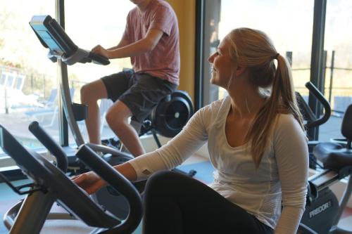 two people riding on exercise bikes in a gym at Summerland Waterfront Resort & Spa in Summerland