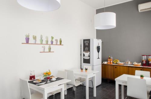 cocina con mesas blancas y nevera blanca en B&B Casa Rosellina, en Palermo