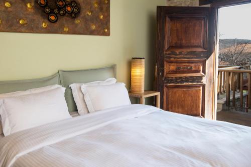 a bedroom with a bed with white sheets and a window at Elafos Spa Hotel in Elliniko