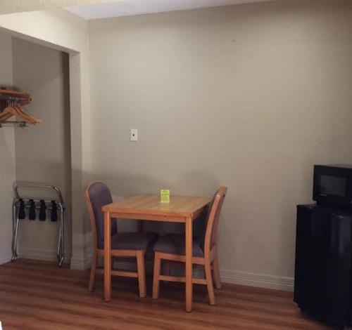 a wooden table and chairs in a room at Stratford House Inn and Suites Temple in Temple