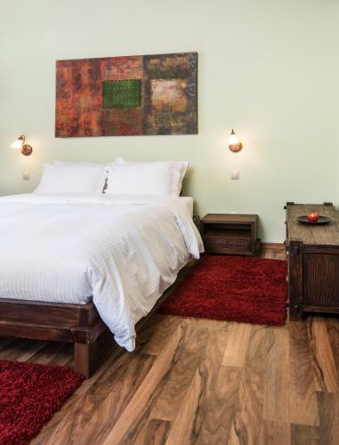 a bedroom with a large bed and a red rug at Elafos Spa Hotel in Elliniko