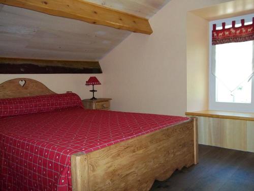 a bedroom with a wooden bed with a red blanket at Ouxis in Orlu