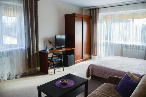 a hotel room with a bed and a desk with a computer at Villa Green in Oświęcim