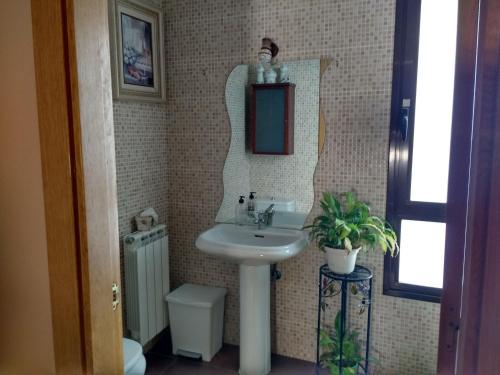 a bathroom with a sink and a mirror and a toilet at Casa Tau in Larrasoaña