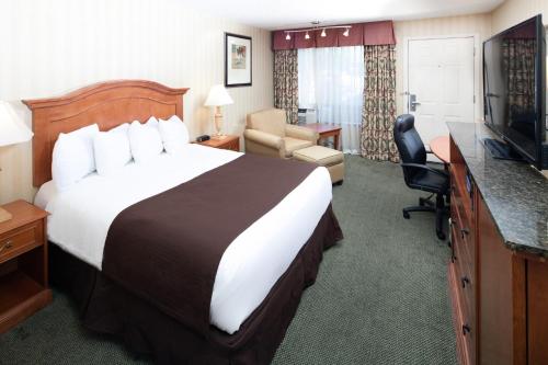 a hotel room with a large bed and a television at Red Lion Inn & Suites Missoula in Missoula
