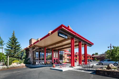 a building with red columns and tables in a parking lot at Red Lion Inn & Suites Missoula in Missoula