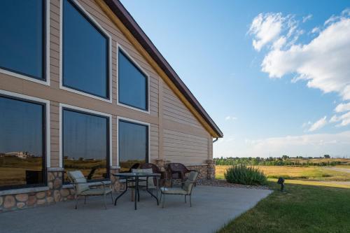a patio with a table and chairs next to a house at AmericInn by Wyndham Belle Fourche in Belle Fourche