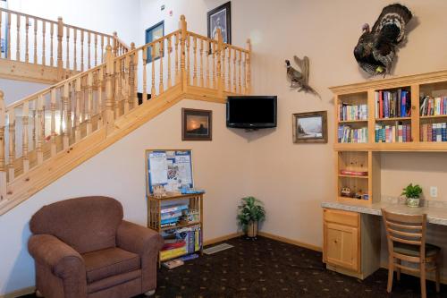 a living room with a staircase and a chair at AmericInn by Wyndham Belle Fourche in Belle Fourche