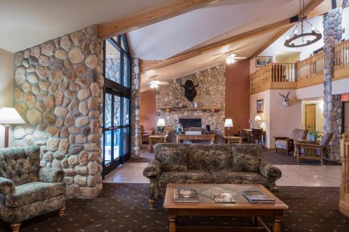 a living room with a large stone wall at AmericInn by Wyndham Belle Fourche in Belle Fourche