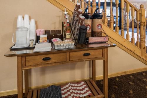 a wooden table next to a staircase with bottles on it at AmericInn by Wyndham Belle Fourche in Belle Fourche