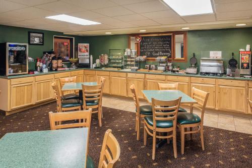 a restaurant with tables and chairs and a counter at AmericInn by Wyndham Belle Fourche in Belle Fourche