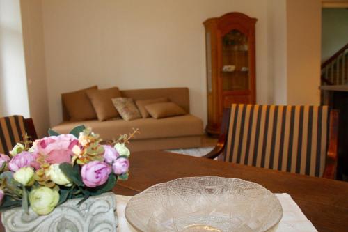 a dining room table with a vase of flowers on it at Austri Villa in Pärnu