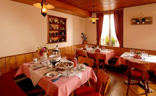 a dining room with tables with pink tablecloths at Hotel Beausite Budget in Interlaken