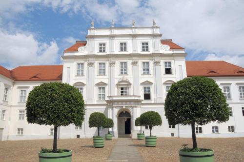 a large white building with trees in front of it at Landhotel Classic in Wensickendorf