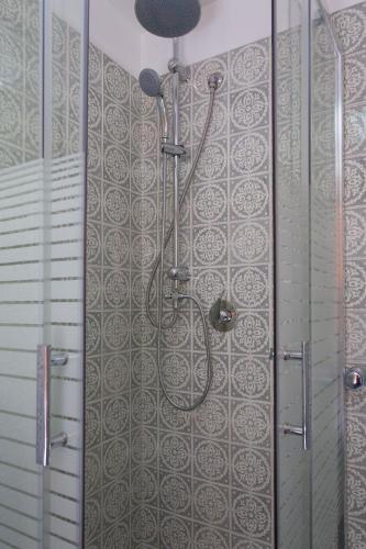 a shower in a bathroom with a tile wall at Piccola Oasi in Mondello