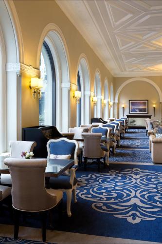 a row of chairs and tables in a room with windows at Fairmont Château Lake Louise in Lake Louise