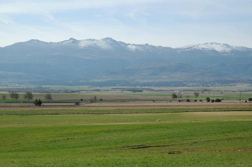 a large green field with mountains in the background at Casa Rural Reposo de Afanes in Muñogalindo