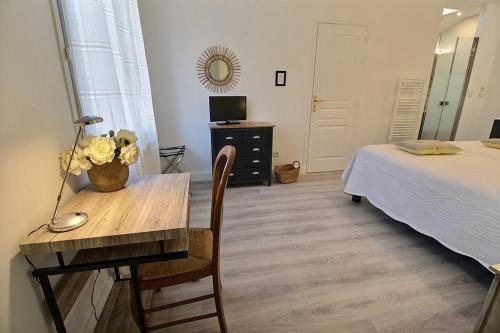 a bedroom with a desk and a bed and a bed and a table at Logis du Lièvre d'or in Montbazon